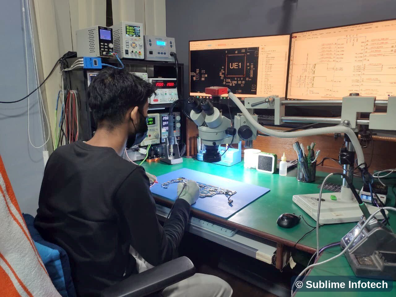 L4 main lab: technician at the microscope with boardview and schematic on two screens