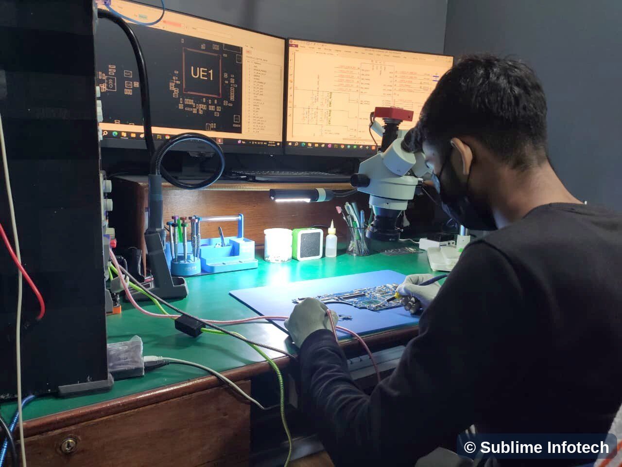 L4 technician working on a board under the microscope