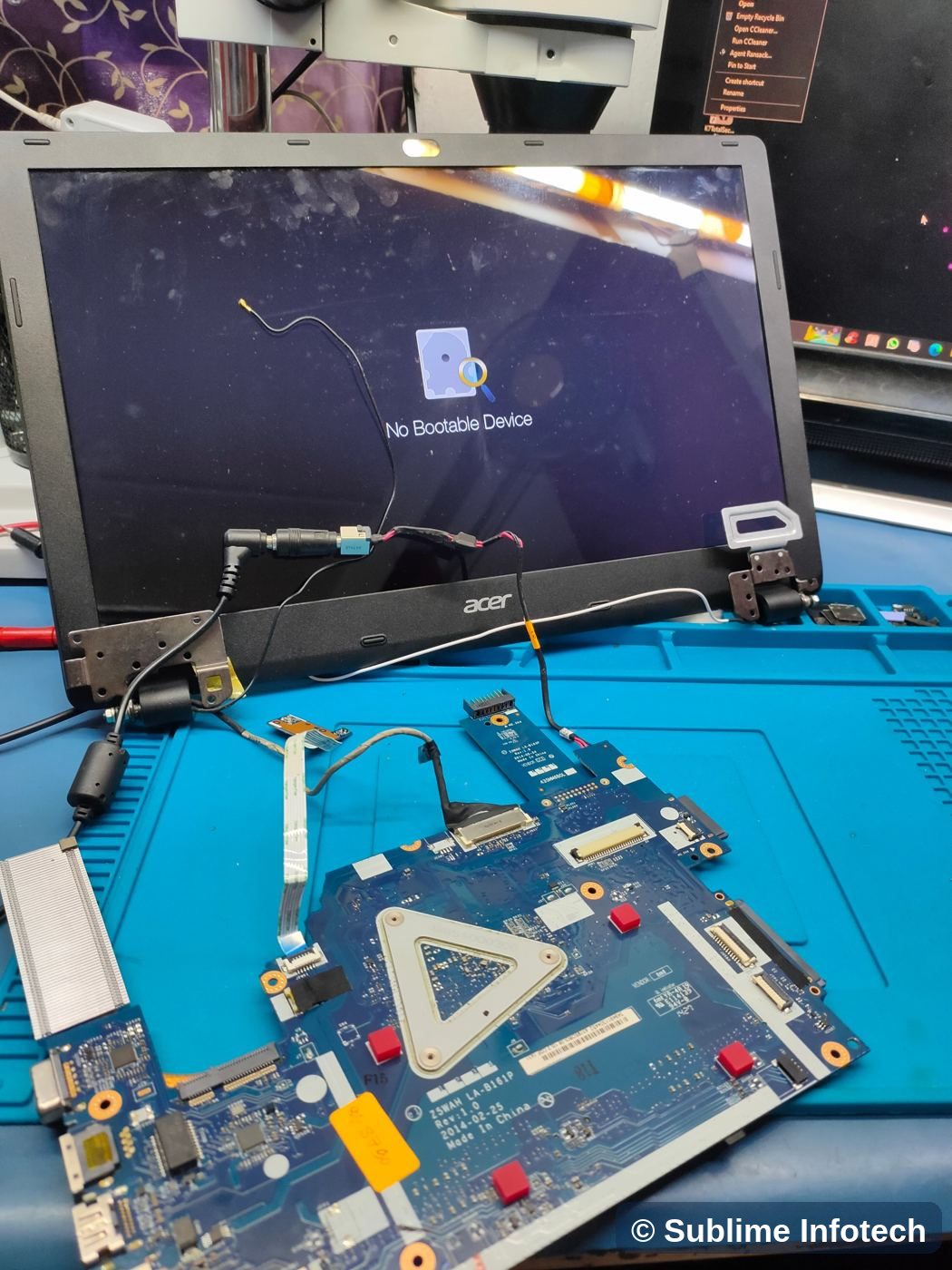 Repaired motherboard powering a laptop screen on the bench